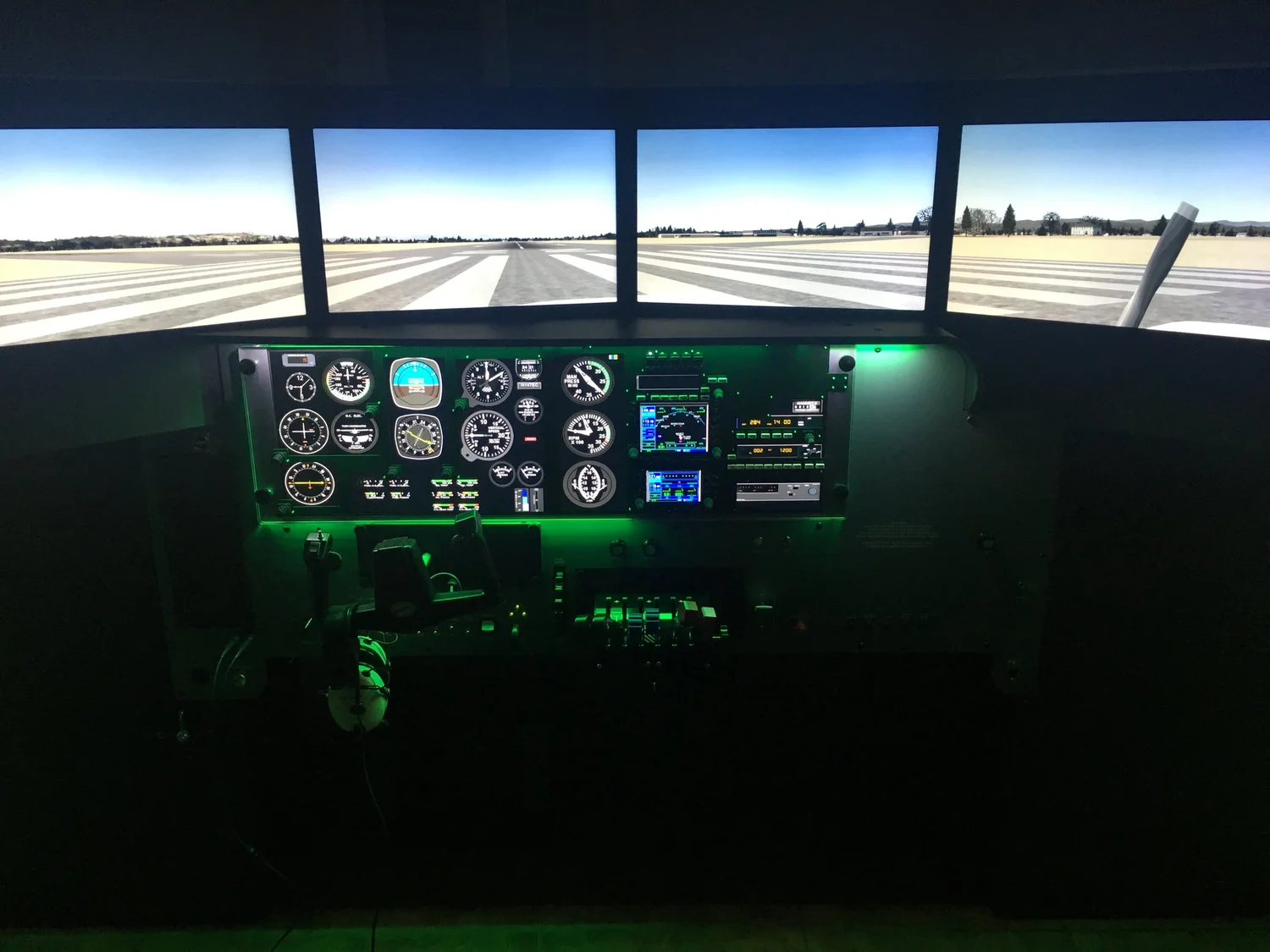 RedBird LD multi-engine simulator with four-panel external visual display on a runway