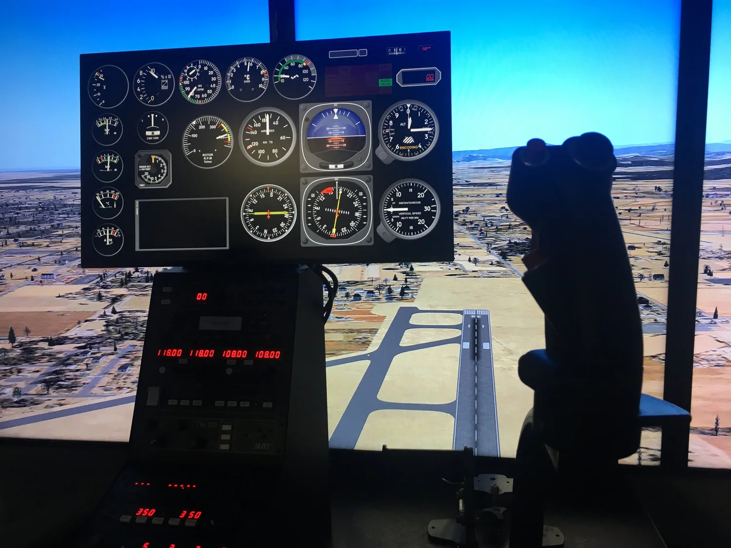 Pilot flying an approach in the Elite TH-100 helicopter simulator